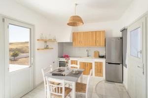 a kitchen with a table with chairs and a refrigerator at Maisonette Sail in Naousa