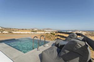 a hot tub on a patio with a view of the ocean at Maisonette Sail privete pool and sea view in Naousa