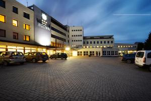 um grande edifício com carros estacionados num parque de estacionamento em Hotel Wodnik em Slok