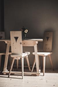uma mesa de madeira com duas cadeiras e uma mesa com um vaso em Einäugl - Briol em Barbiano
