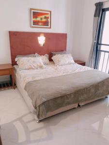 a bedroom with a large bed with a red headboard at Riviera palms 1 Luxury 1 BHK apartment with Swimmimg Pool view- Arpora - near baga beach in Old Goa