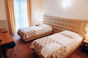 a hotel room with two beds and a desk at Hotel Hvala Superior - Topli Val in Kobarid