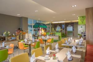 ein Restaurant mit Tischen und Stühlen sowie weißen Servietten in der Unterkunft KHAS Gresik in Gresik