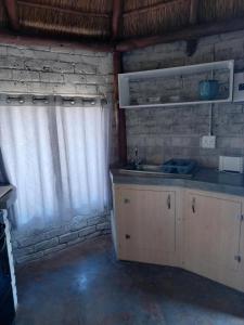 a kitchen with a sink and a brick wall at Slypsteen Guest Farm in Sternham