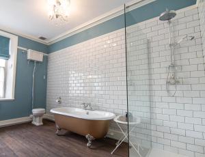 a bathroom with a tub and a glass shower at Oakhill in Matlock