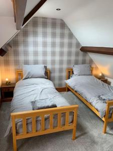 a bedroom with two beds in a attic at Cosy Bay Cottage in Scarborough