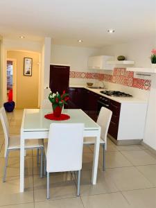 a kitchen and dining room with a white table and chairs at Casa Marilisa in Maiori