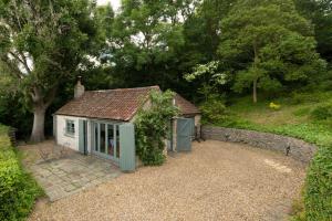una pequeña casa con una puerta verde en un patio en Perfect Getaway Close to Bath and Bristol en Bitton