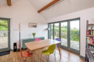 ein Esszimmer mit einem Tisch und bunten Stühlen in der Unterkunft Perfect Getaway Close to Bath and Bristol in Bitton