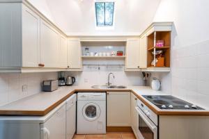 a kitchen with white cabinets and a washer and dryer at Perfect Getaway Close to Bath and Bristol in Bitton