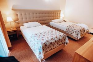 a hotel room with two beds in a room at Hotel Hvala Superior - Topli Val in Kobarid