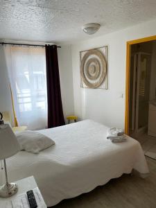 Un dormitorio con una gran cama blanca y una ventana en le relais, en Fontenay-Trésigny