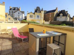 patio con mesa y sillas en el balcón en La Caravelle au plus près de la mer, en Saint-Malo