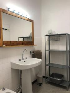 baño con lavabo, espejo y estante en La Caravelle au plus près de la mer en Saint-Malo