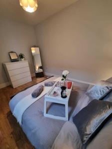 ein Schlafzimmer mit 2 Betten und einem Tisch mit Blumen darauf in der Unterkunft Serene getaway Apartments in Maidstone