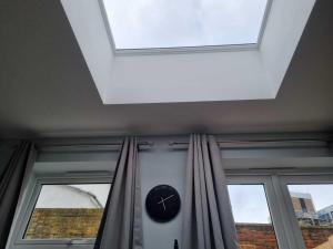 uma clarabóia num quarto com um relógio e duas janelas em Serene getaway Apartments em Maidstone