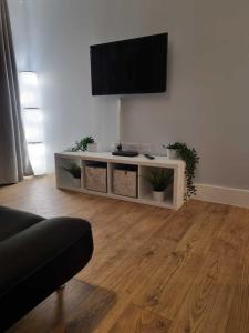 a living room with a flat screen tv on a wall at Serene getaway Apartments in Maidstone