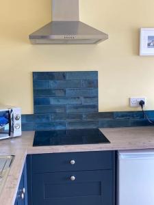 a kitchen with a blue counter top with a stove at Beautiful one bed apartment with stunning sea view in Waterford