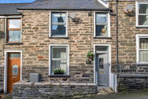 a brick house with white doors and windows at Finest Retreats - Bwthyn Llechi, Slate Cottage in Blaenau-Ffestiniog