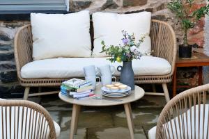 a coffee table with books and a vase of flowers at Finest Retreats - Bwthyn Llechi, Slate Cottage in Blaenau-Ffestiniog