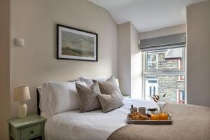 a bedroom with a bed with a tray of food on it at Finest Retreats - Bwthyn Llechi, Slate Cottage in Blaenau-Ffestiniog