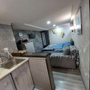 mały pokój z łóżkiem i kuchnią ze zlewem w obiekcie Beqa house w mieście Tbilisi City
