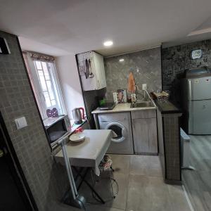 a small kitchen with a sink and a washing machine at Beqa house in Tbilisi City