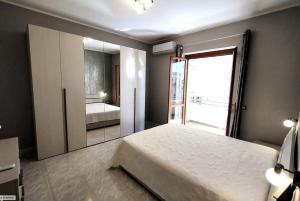 ヴィボ・バレンティア・マリーナにあるWow House di Marinaのベッドルーム(ベッド1台、大きな鏡付)