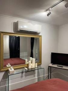 ein Schlafzimmer mit einem Spiegel und einem Bett mit Kerzen in der Unterkunft The mini New-Yorker in Sydney