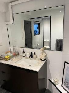 a bathroom with a sink and a large mirror at The mini New-Yorker in Sydney