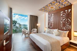 ein Schlafzimmer mit einem großen Bett und einem großen Fenster in der Unterkunft Grand Serendib Hotel in Kandy