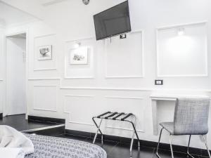 a living room with a tv and a chair at Rome Central Inn in Rome