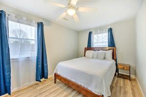 een slaapkamer met een bed met blauwe gordijnen en een raam bij Richmond Home with Fire Pit - 12 Mi to Downtown in Richmond