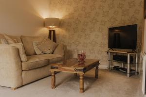 a living room with a couch and a coffee table at Newclose Farm Cottages in Yarmouth