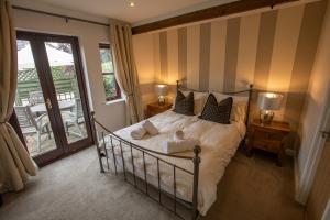 a bedroom with a large bed with striped walls at Newclose Farm Cottages in Yarmouth