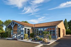 a building with a gas pump in front of it at Kyriad Niort - La Crèche in La Creche