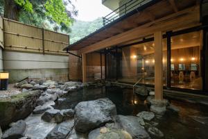 a house with a pond in front of a building at Sakahijiri Nikko in Nikko