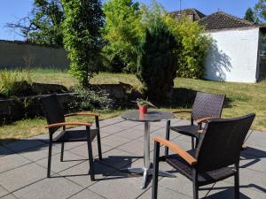 a patio with three chairs and a table in a yard at Villa in Meisenheim