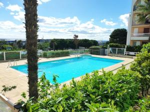 una gran piscina azul junto a un edificio en Beau duplex vue mer - terrasse - garage - wifi, en Sète