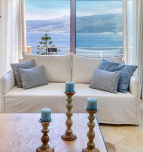 a living room with a white couch with blue candles at Artemis ΙnCreteble Cretan Resindences Collection in Sitia