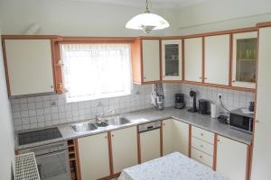 una cucina con mobili bianchi e un lavandino di Barbara's sweet home Preveza a Preveza