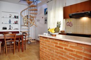 a kitchen with a counter with a bowl of fruit on it at Residenza Le Sirene in Santa Domenica