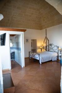 a large room with a bed and a tv at Dimora Santa Barbara in Matera