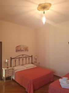a bedroom with a bed with a red bedspread at Le Corti del Casale in Alberobello