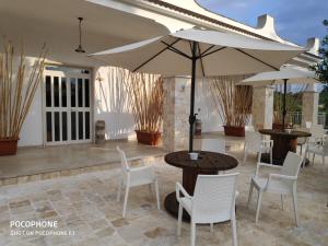 a patio with a table and chairs and an umbrella at Le Corti del Casale in Alberobello