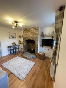 a living room with a stone fireplace and a table at Bernards Hill in Bridgnorth