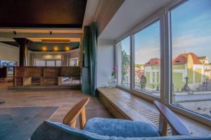 a living room with a large window and a piano at Uroczy apartament Wita Stwosza most Kłodzko in Kłodzko