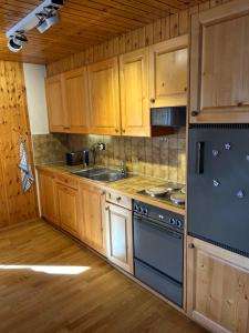 una cocina con armarios de madera y un horno de fogón azul en Heida, studio ensoleillé au village avec magnifique vue sur la Dent-Blanche, en Evolène