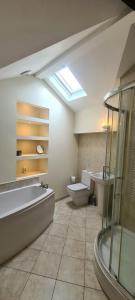 a bathroom with a tub and a toilet and a sink at Lovely 2 bedroom apartment in Kendal town centre in Kendal