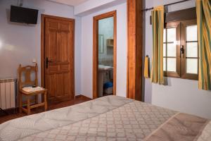 1 dormitorio con cama, ventana y puerta en Hospedaje Rural Casa Parri, en Poveda de la Sierra